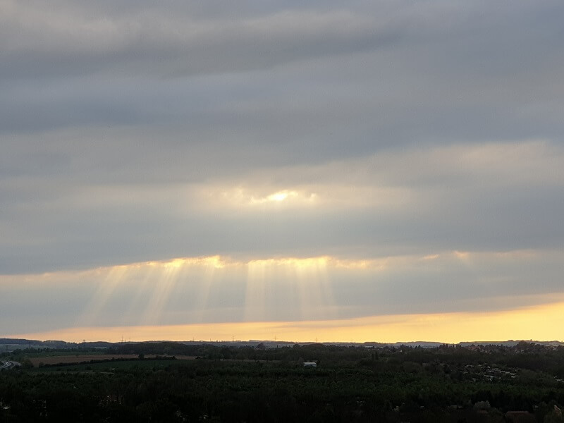 Sonnenstrahlen scheinen durch eine dicke Wolkendecke