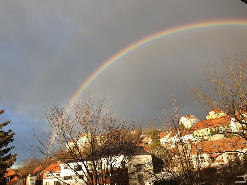 Regenbogen vor grauem Himmel